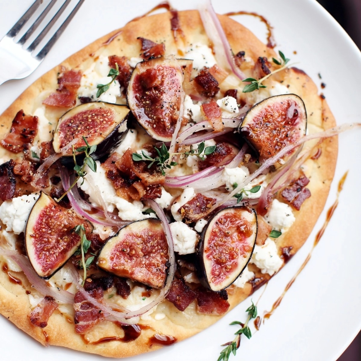 Hausgemachter gerösteter Balsamico-Feigen- und Speck-Flammkuchen, mit Balsamico-Glasur beträufelt und warm serviert.