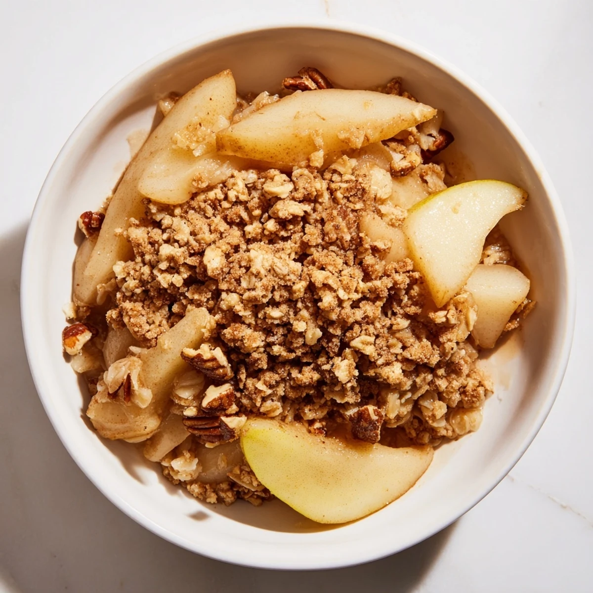 A bubbling Spiced Pear Crisp with a golden, oat-filled topping, ready to serve warm.