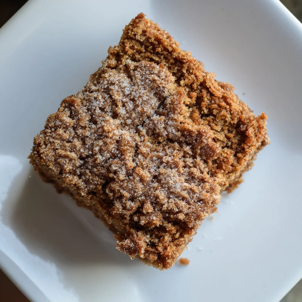 A slice of gingerbread, moist and spiced, ready to serve with powdered sugar on top.