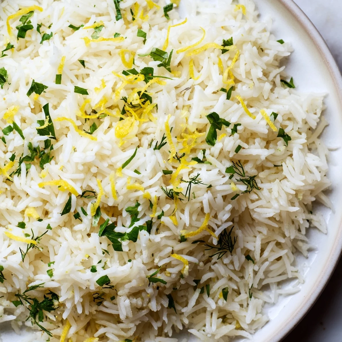Fluffy Lemon Herb Rice served warm, garnished with fresh herbs and a wedge of lemon.