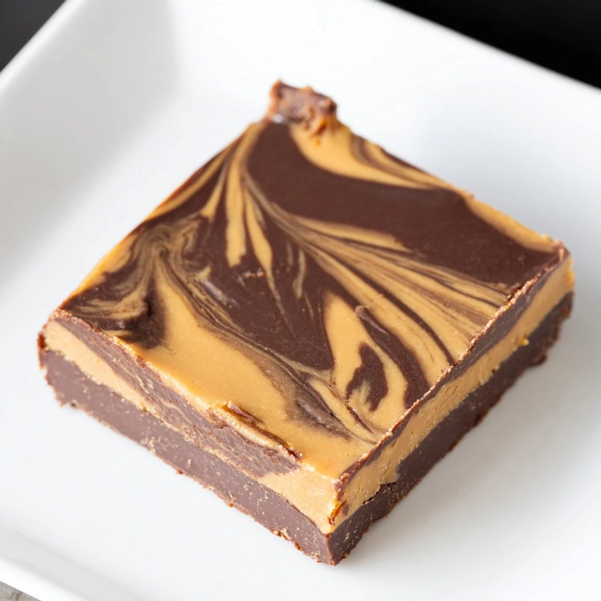 Silky smooth Chocolate Peanut Butter Fudge, swirled with peanut butter, ready to be cut and enjoyed.