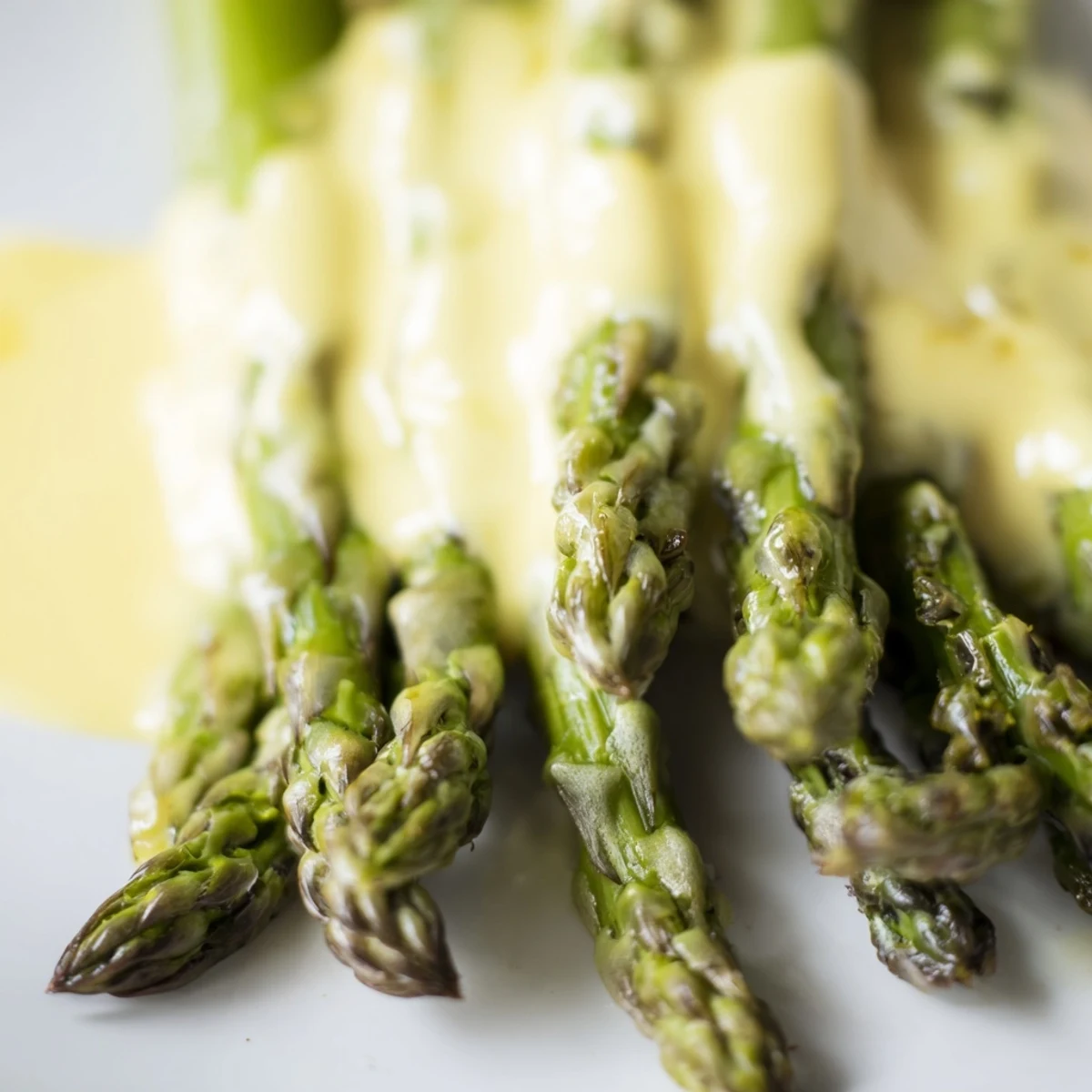 Golden roasted asparagus with Hollandaise sauce, served warm alongside a lemon wedge for bright acidity.