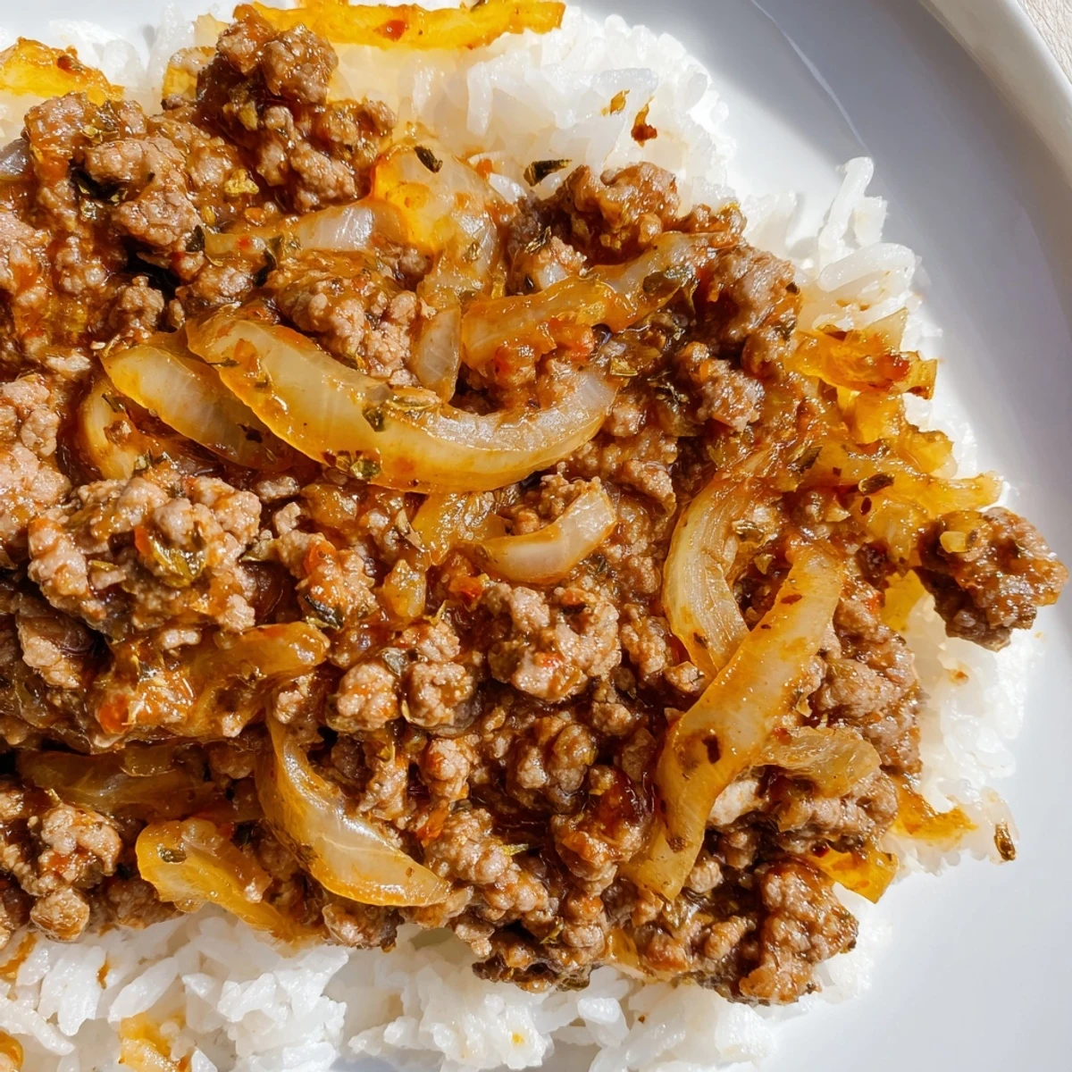 Sizzling pan of Beef Mince with Onions paired with forkfuls of pasta.