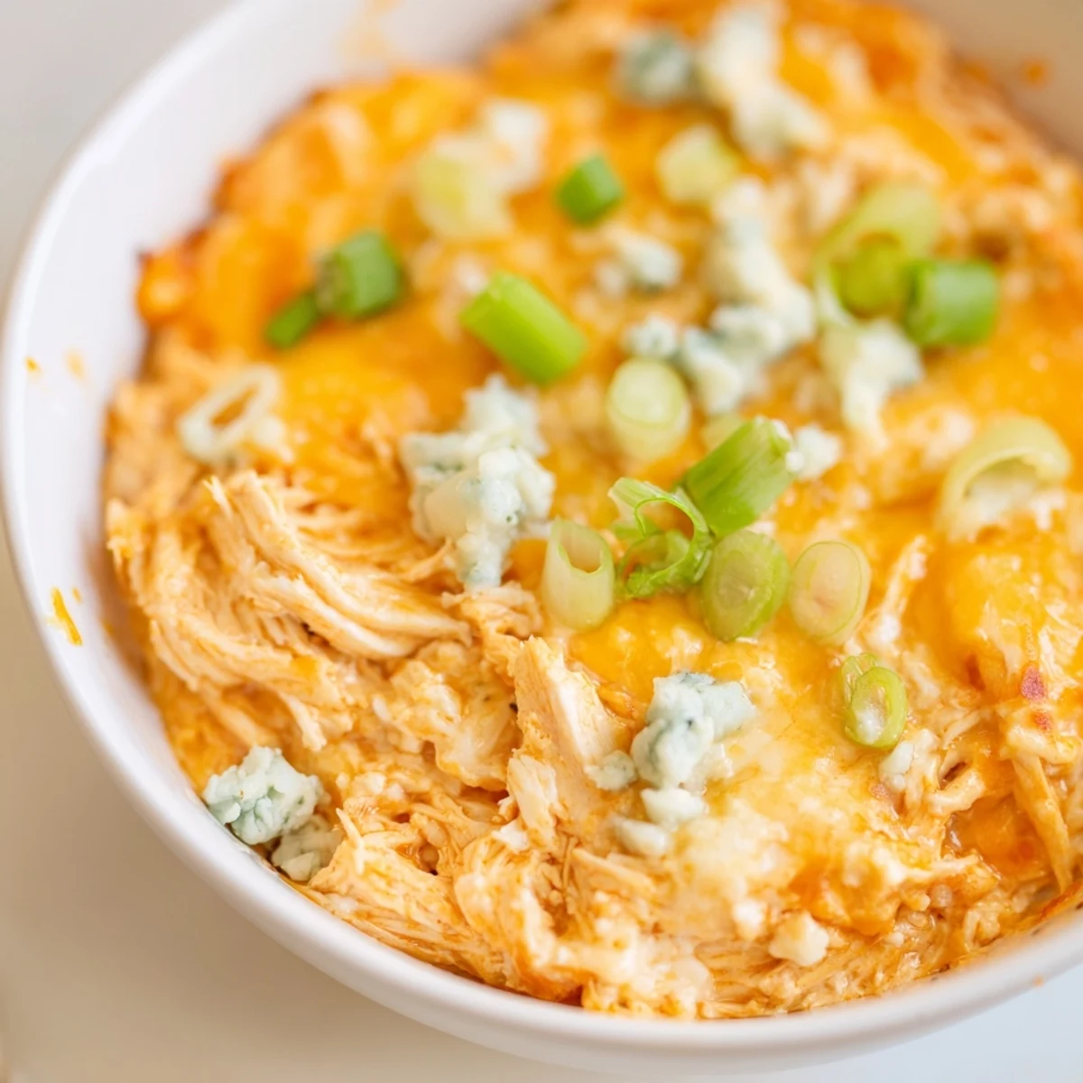 Golden-brown Spicy Buffalo Chicken Dip with celery sticks, a gooey, baked appetizer for game day gatherings.