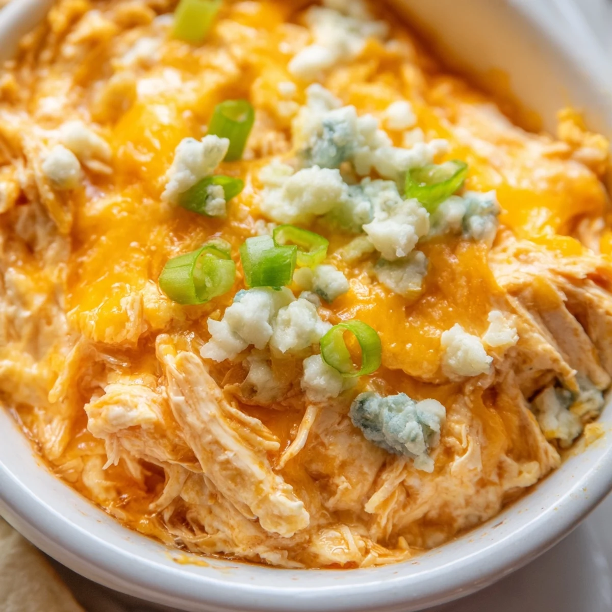 Creamy Spicy Buffalo Chicken Dip bubbling from the oven, garnished with celery sticks for cool, crisp dipping.