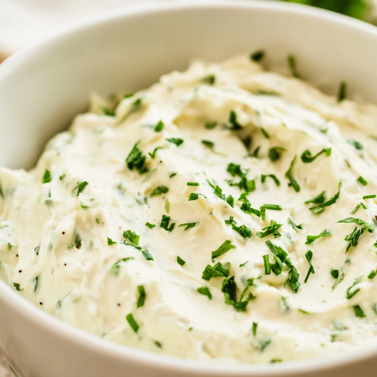 Cremige Snack-Dip mit frischen Kräutern, gereicht zu knackigem Gemüse für eine gesunde Vorspeise.