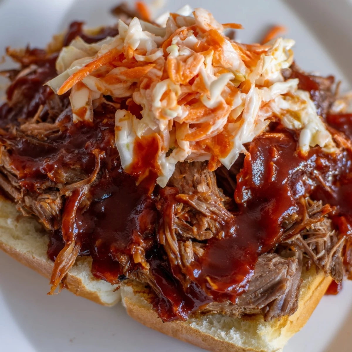 Homestyle Slow Cooker Pulled Beef Sandwiches with zesty coleslaw, served hot alongside extra sauce for dipping.