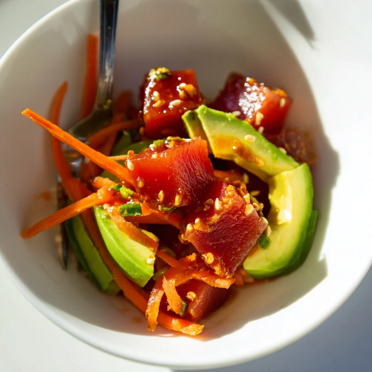 Servier den leckeren Spicy Tuna Poke Bowl mit Avocado und Sesam, ideal für ein gesundes Abendessen.