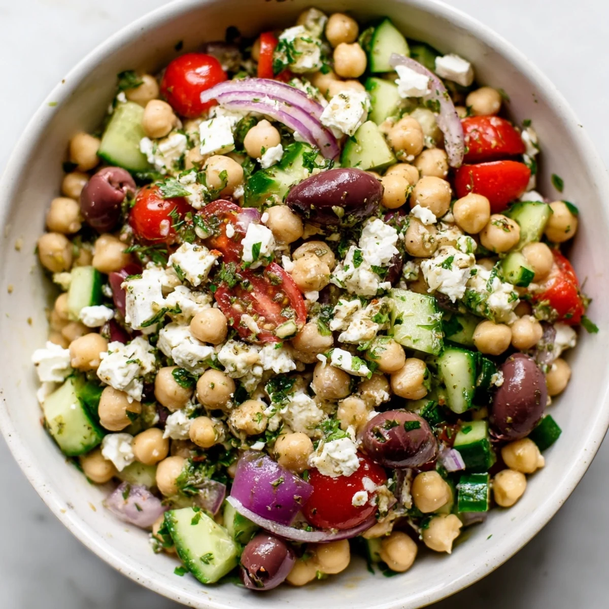 Bunt angerichteter Mediterranean Chickpea Salad with Feta and Olives auf einem Holztisch für ein Sommeressen