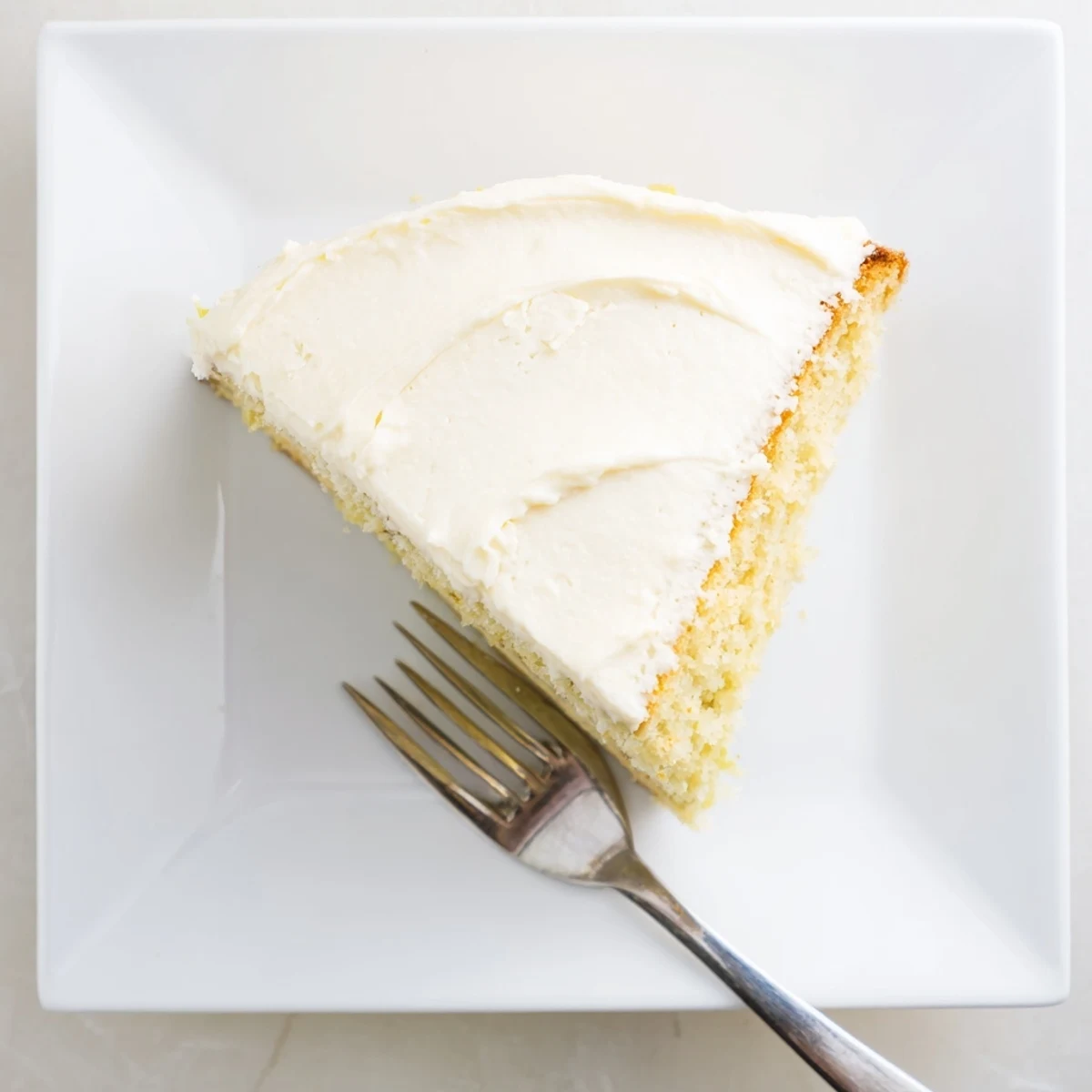 Ein zitroniger Lemon Cake Slice mit luftiger Frosting und frischen Zitronenzesten für Dessert-Liebhaber.