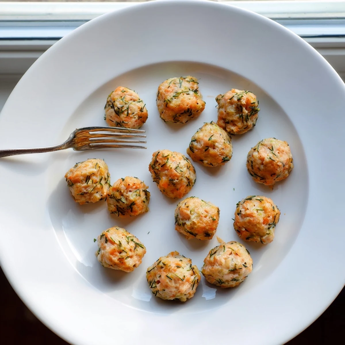 Succulent Baked Salmon Snack Bites served with lemon wedges and dill, perfect for healthy snacking.