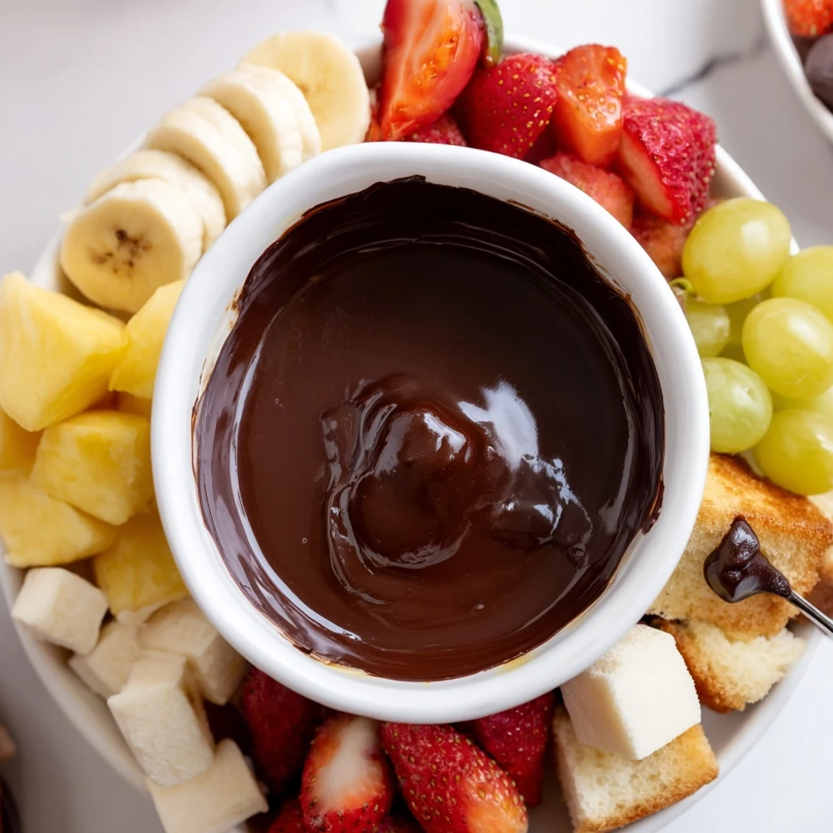 Silky Romantic Chocolate Fondue bubbling in a fondue pot, surrounded by vibrant fresh fruit slices on an elegant platter for a date night.