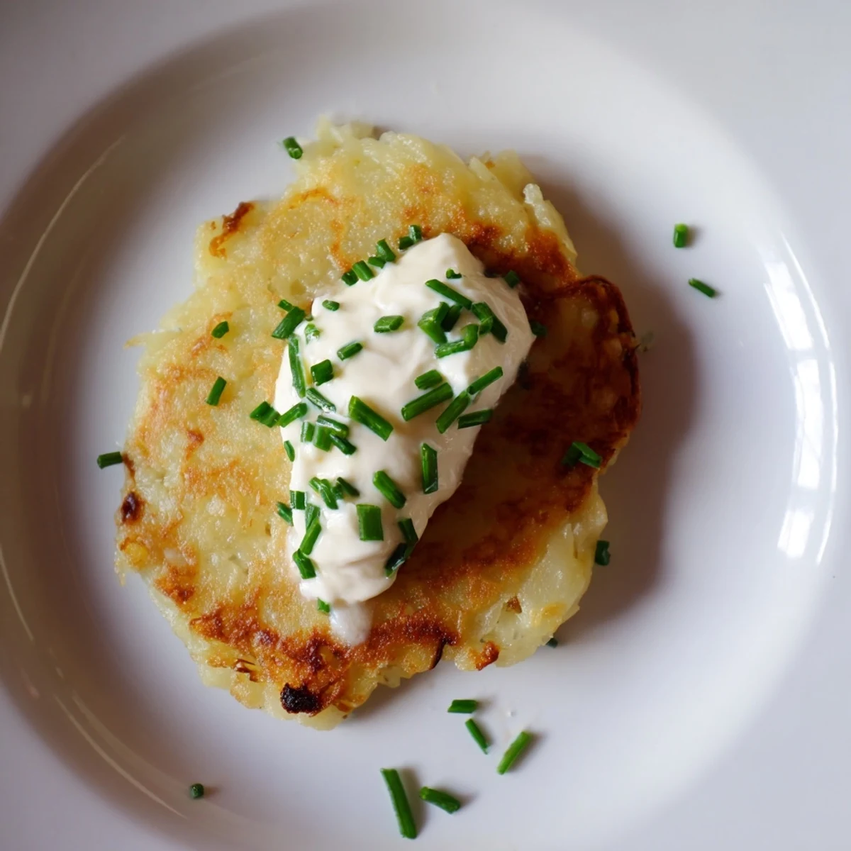 Plated Irish Boxty with Sour Cream served alongside smoked salmon, offering a savory and traditional pairing.