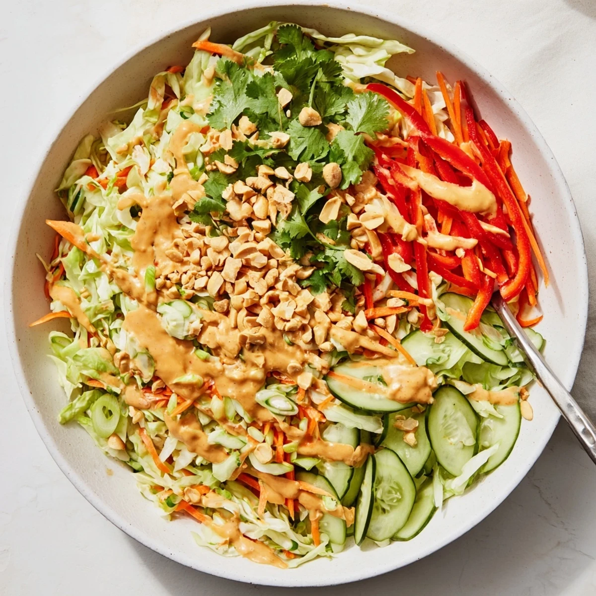 Bunter Thai-Salat mit Kohl und Karotten, übergossen mit aromatischer Erdnussdressing