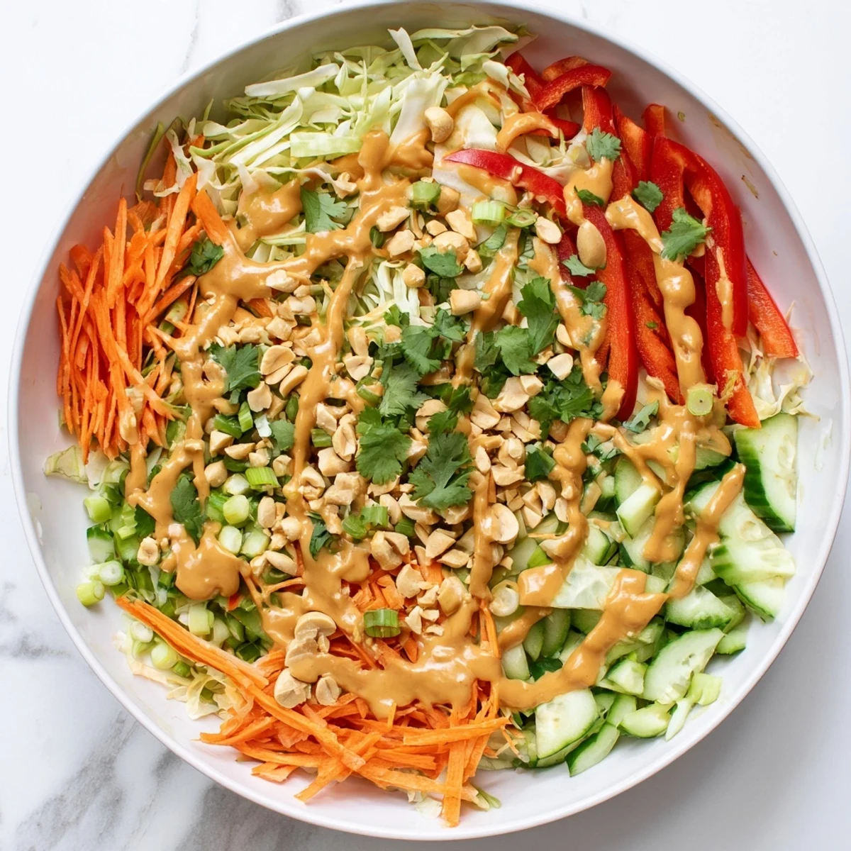 Vegetarischer Thai-Salat mit knusprigem Gemüse und hausgemachter Erdnuss-Sauce auf einem Teller