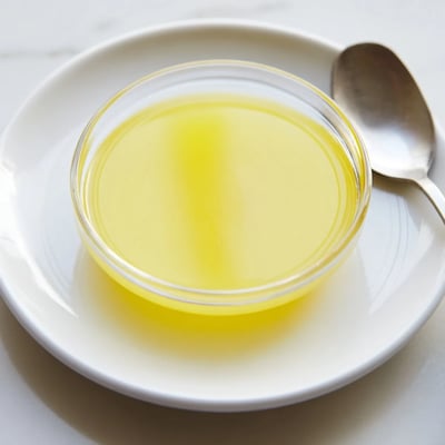 A small glass of bright yellow lemon juice, freshly squeezed and ready to use.