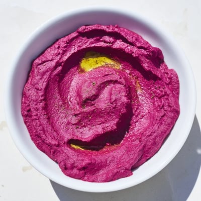 Frisch gebackene Pita-Chips neben einer Schüssel hausgemachten Rote Bete Hummus, perfekt fürs Teilen als gesunder Snack.